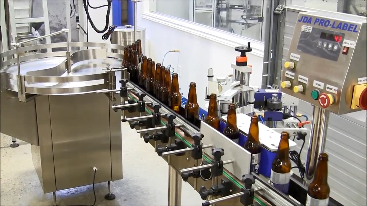 JDA Pro-Label inline wrap around labeler labeling bottles
